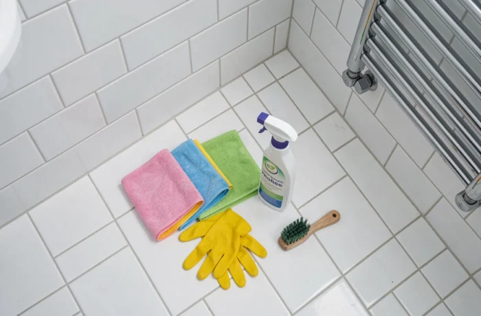 Kit de nettoyage professionnel posé sur le carrelage d'une salle de bain dans un appartement parisien